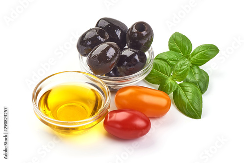 Olive oil in a bowl with tomatoes and olives, isolated on white background