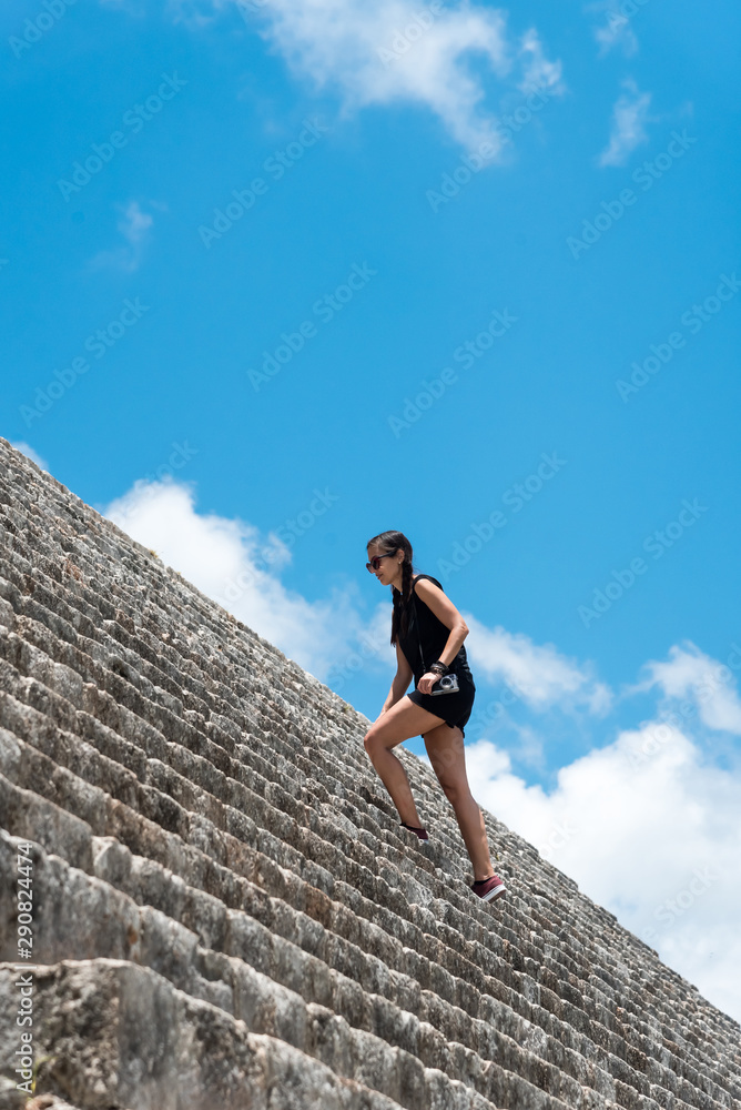 Obraz na plátně Woman climbing stairs on mayan ruins