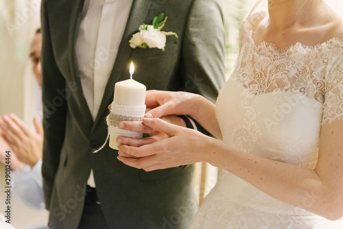 the bride and groom are holding a lighted candle in their hands