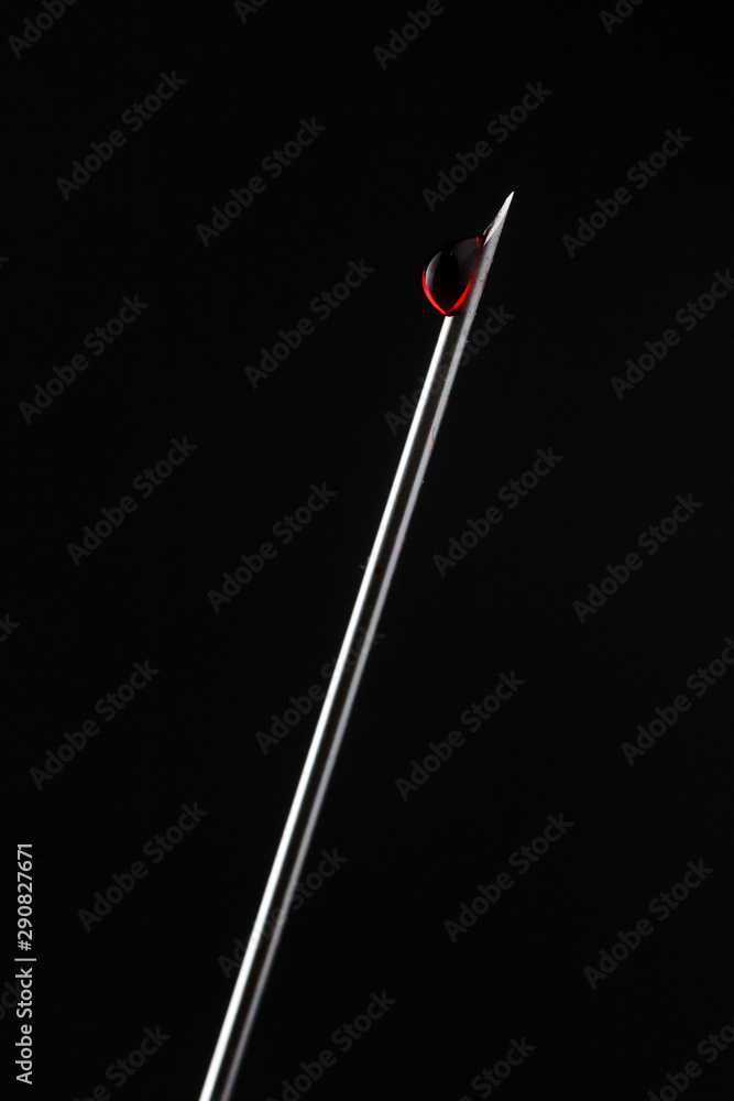 syringe tip with blood drop on a black background syringe tip with blood drop on a black background