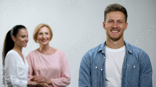 Woman and mother-in-law holding hands, admiring male in family, relations