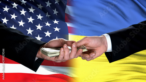 USA and Ukraine officials exchanging money, flag background, cooperation