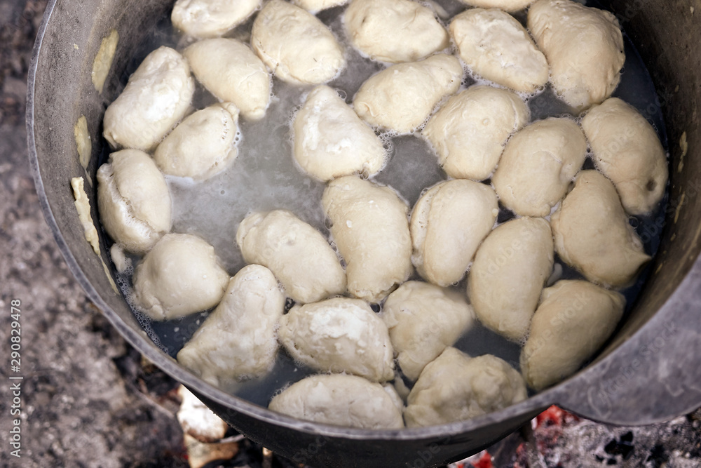 Dumplings are boiling in cauldron. Preparation of Ukrainian traditional