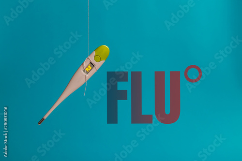 Thermometer next to the flu inscription on a blue background. Cold and flu concepts. Healthcare, medicine, flu and treatment concept