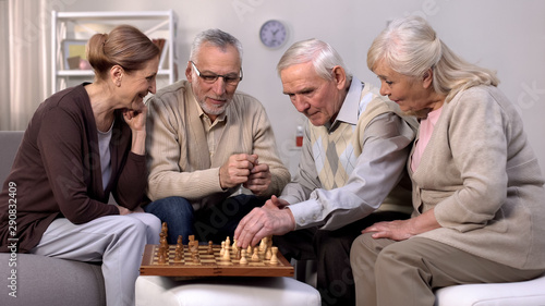 Senior friends playing chess at home  retirement leisure time  togetherness