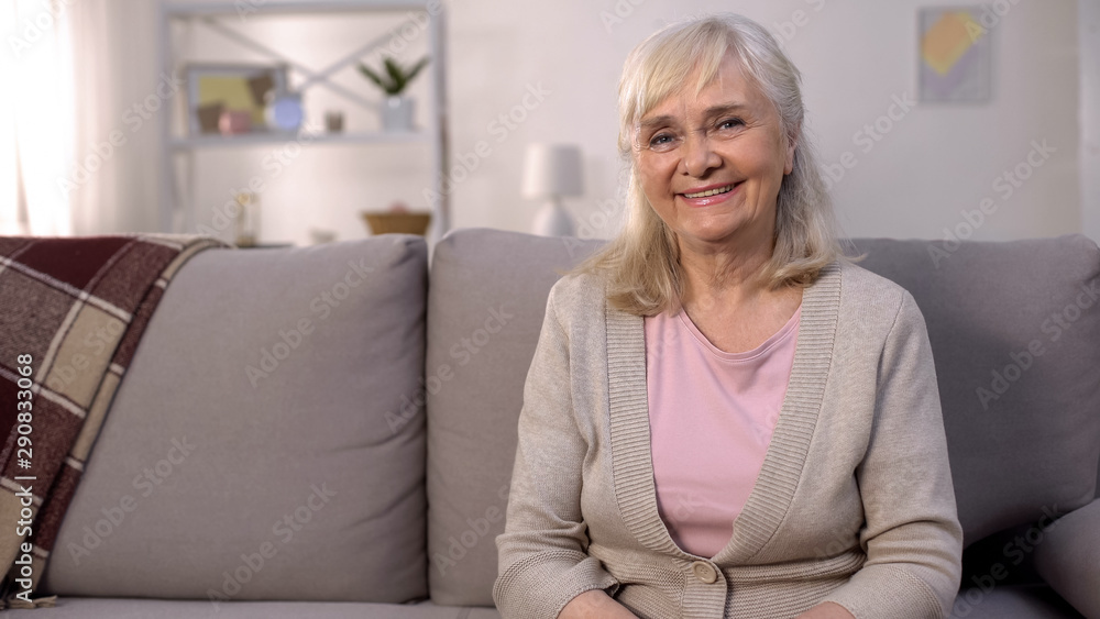 Happy healthy old woman smiling camera sitting sofa, retirement wellness, beauty Happy healthy old woman smiling camera sitting sofa, retirement wellness, beauty