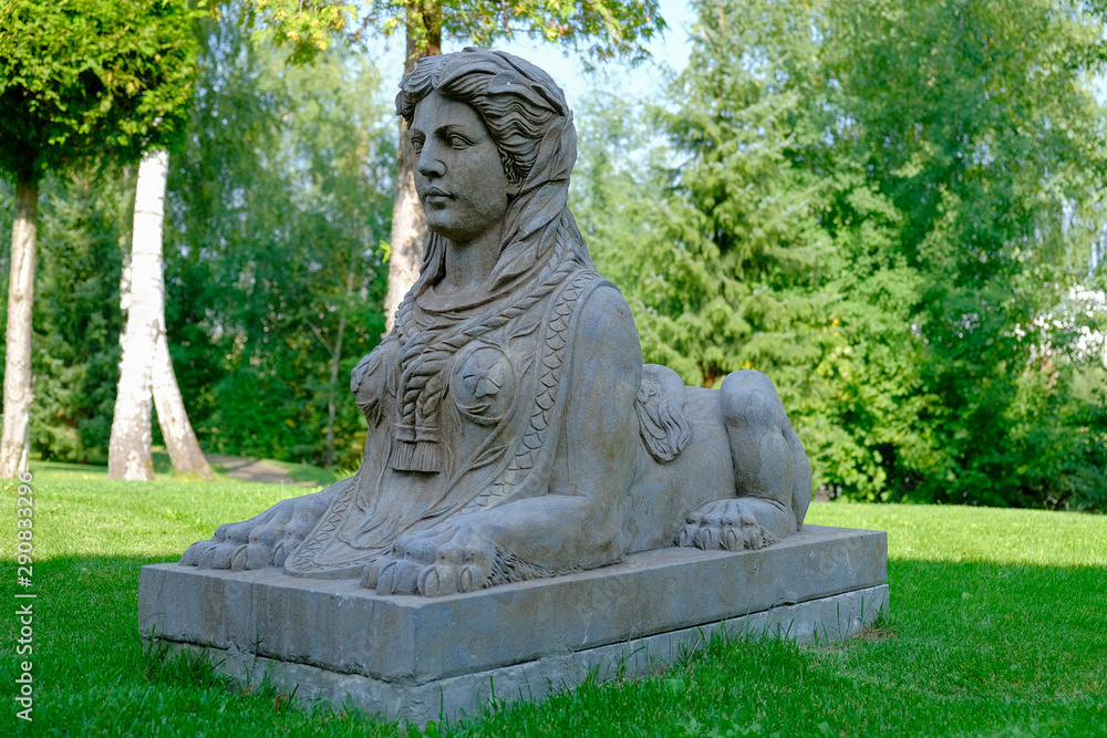 Stone ancient sphinx sculpture in a park on a green lawn. Stone ancient sphinx sculpture in a park on a green lawn.