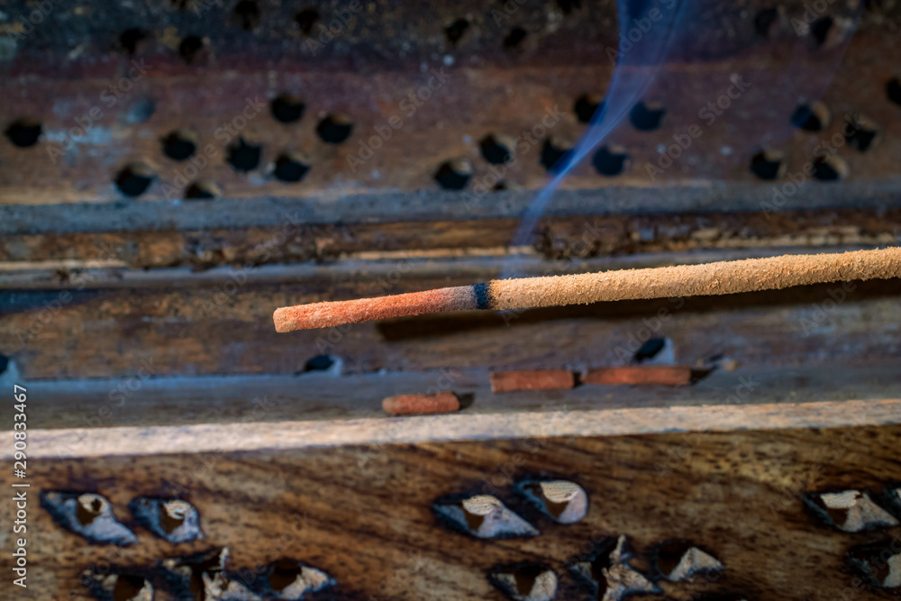 Indian incense stick on a wooden stand closeup Indian incense stick on a wooden stand closeup