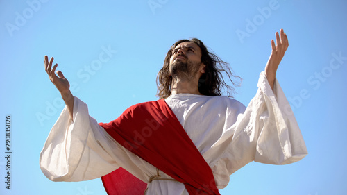 Fotografie Jesus raising hands to sky and praying, resurrection and ascension of Christ