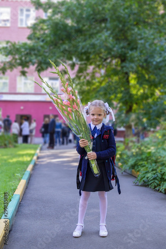 girl with bouquet of flowers goes to school for the first time