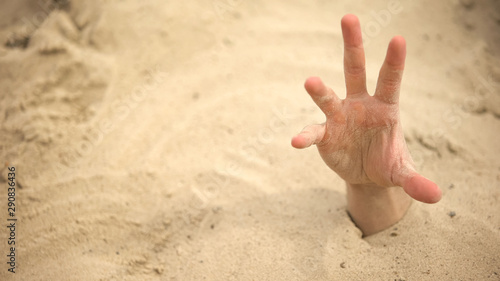 Hand sinking in quicksand, trying to get out, tips to survive in desert, buried