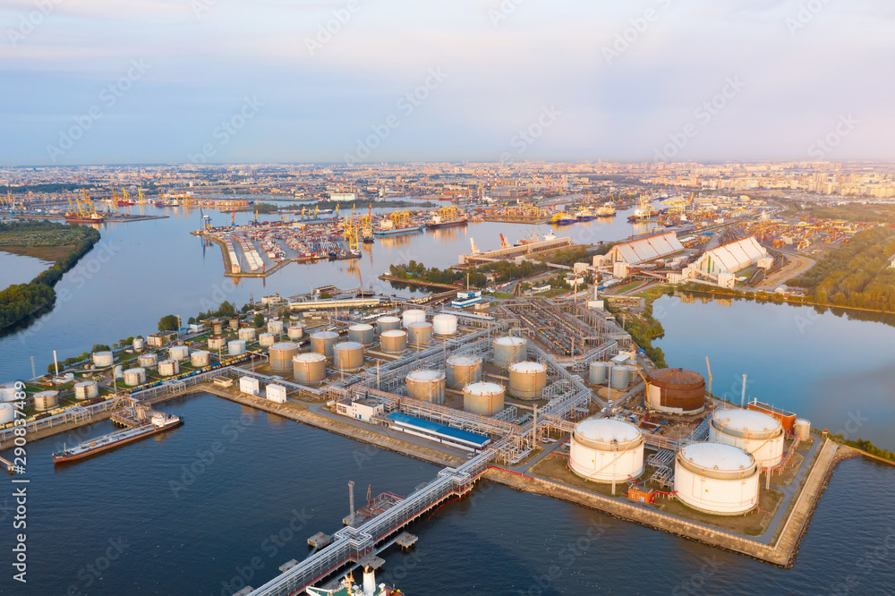 Aerial view of large fuel storage tanks at oil refinery industrial zone in the cargo seaport.