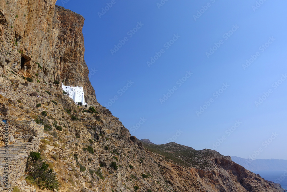 Photo of picturesque Monastery of Panagia Hozoviotissa built on a steep cliff with view to Aegean deep blue, Amorgos island, Cyclades, Greece