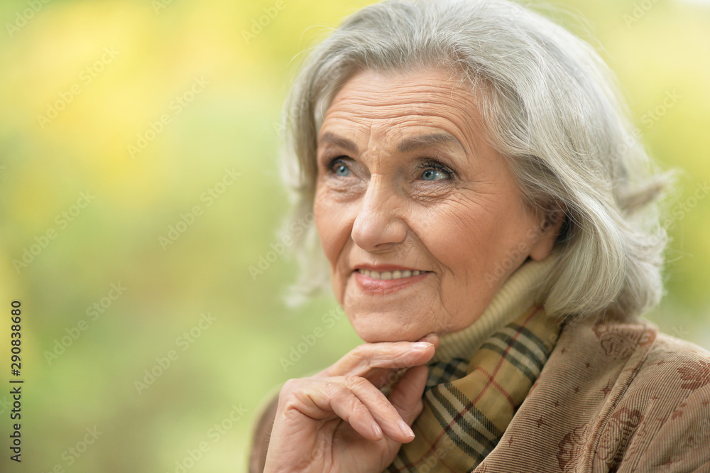Portrait of senior beautiful woman with leaf posing outdoors Portrait of senior beautiful woman with leaf posing outdoors