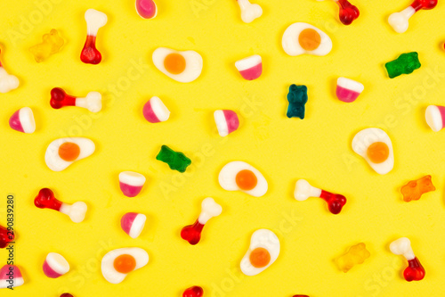Assorted jelly sweets on yellow background. Pattern.