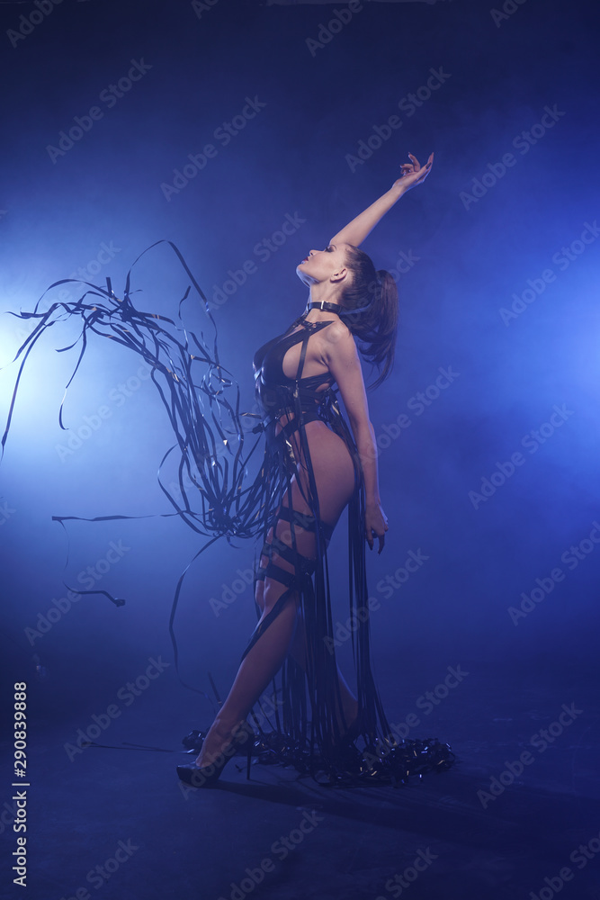 Young sexy woman dancer posing in the smoke