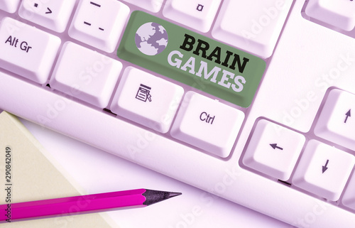 Writing note showing Brain Games. Business concept for psychological tactic to analysisipulate or intimidate with opponent White pc keyboard with note paper above the white background photo