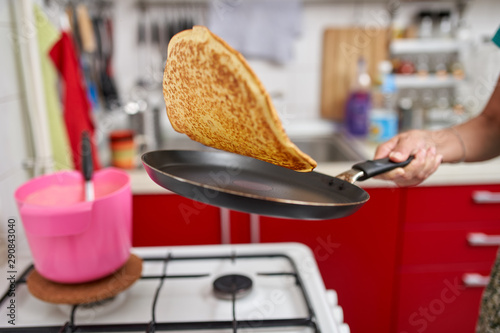 Woman flipping pancake in the pan