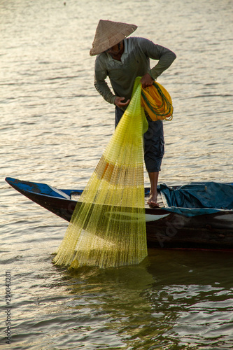 Man net fishing at sunset, Hoi An, Vietnam