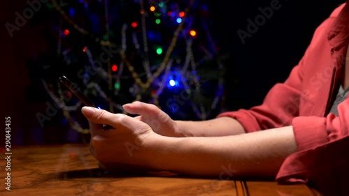 Happy New Year and Merry Christmas. close-up. female hands texting sms message on smartphone photo