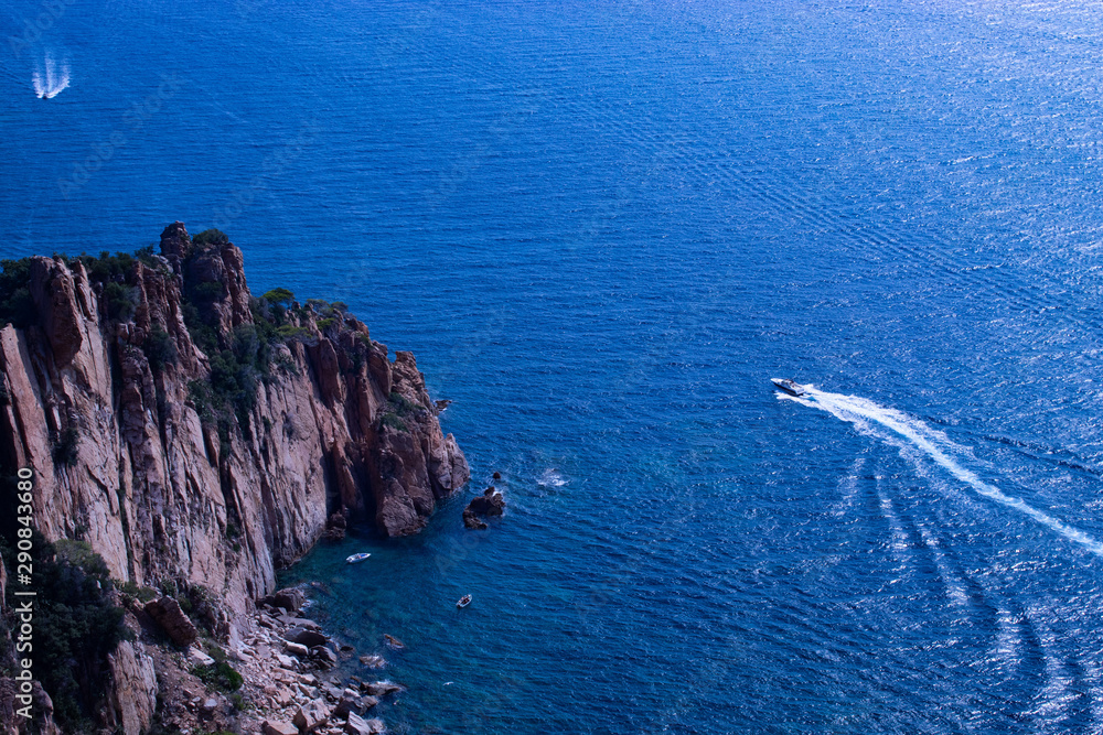 Cliffs at sea with motorboat