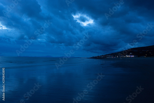 Obraz na płótnie Lightened town next to beach w salonie