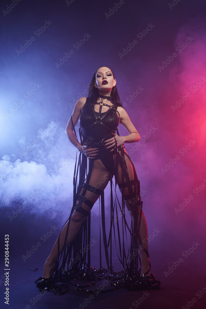 Obraz premium Young sexy woman dancer posing in the smoke