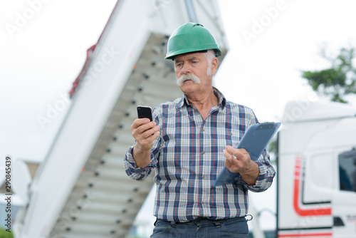 senior engineer man in suit and helmet talking mobile phone