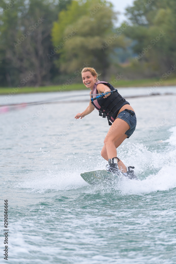 young pretty woman riding wakeboard on wave young pretty woman riding wakeboard on wave