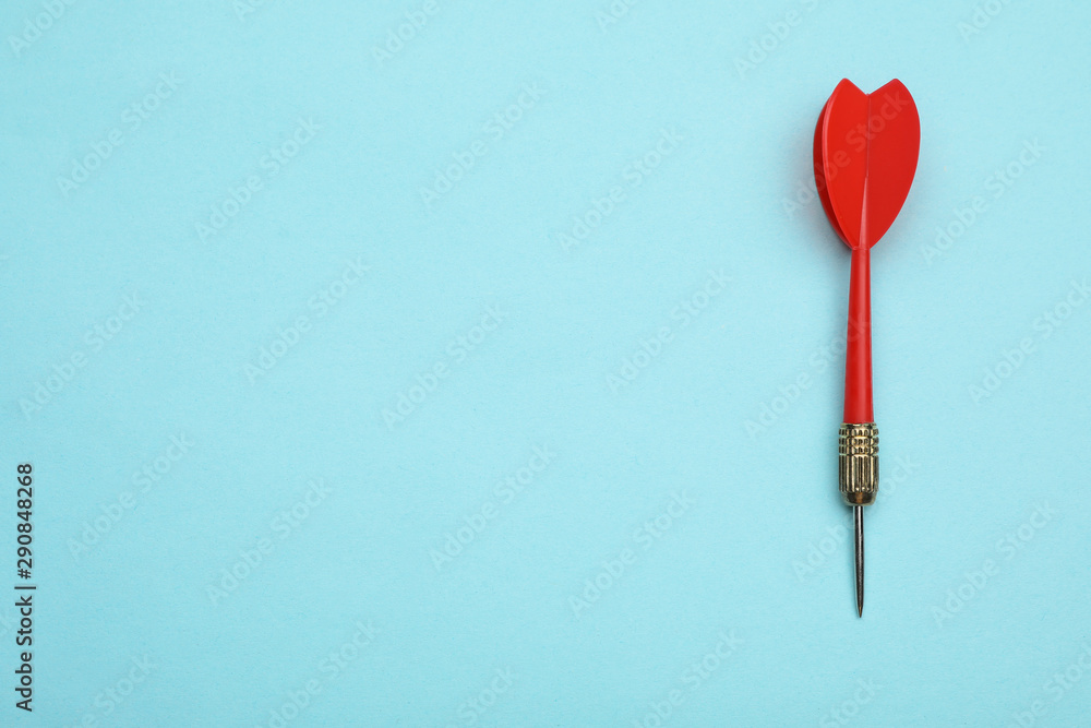 Red dart arrow on blue background, top view with space for text Red dart arrow on blue background, top view with space for text