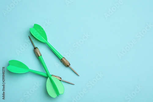 Green dart arrows on blue background, flat lay with space for text