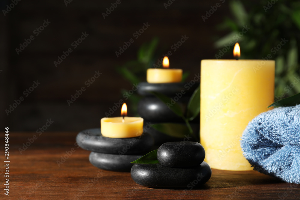 Composition with candles and spa stones on wooden table. Space for text Composition with candles and spa stones on wooden table. Space for text