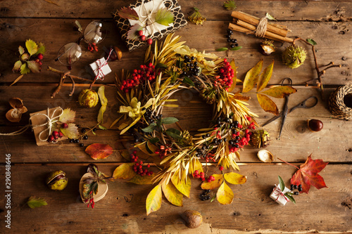 Fototapeta Naklejka Na Ścianę i Meble -  Autumn composition with Wreath,dry leaves gifts and berries/making autumn wreath