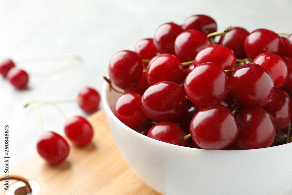 Bowl of tasty ripe cherries on board, closeup Bowl of tasty ripe cherries on board, closeup