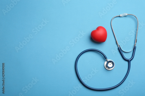 Stethoscope, red heart and space for text on blue background, flat lay. Health insurance concept