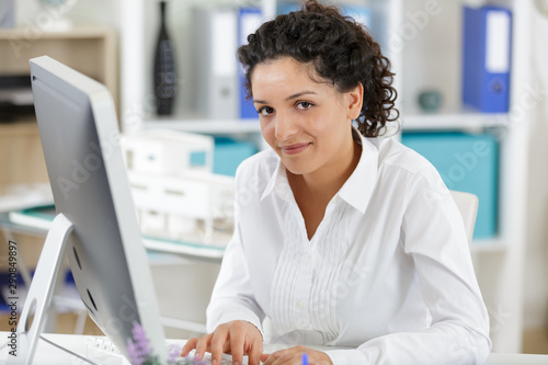 Tableau sur toile young woman using desktop computer in an office