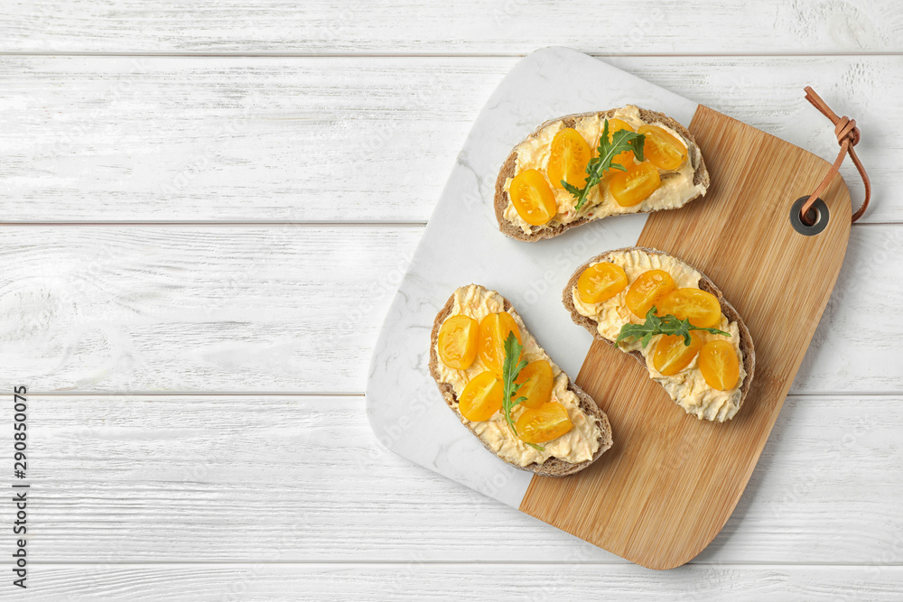 Tasty fresh tomato bruschettas on white wooden table, flat lay. Space for text