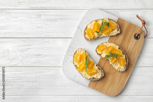 Tasty fresh tomato bruschettas on white wooden table, flat lay. Space for text