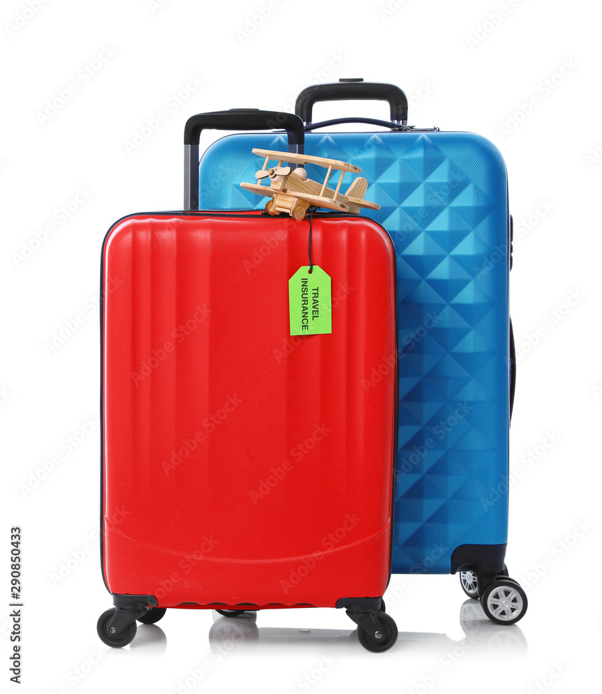 Red and blue suitcases with TRAVEL INSURANCE label on white background Red and blue suitcases with TRAVEL INSURANCE label on white background