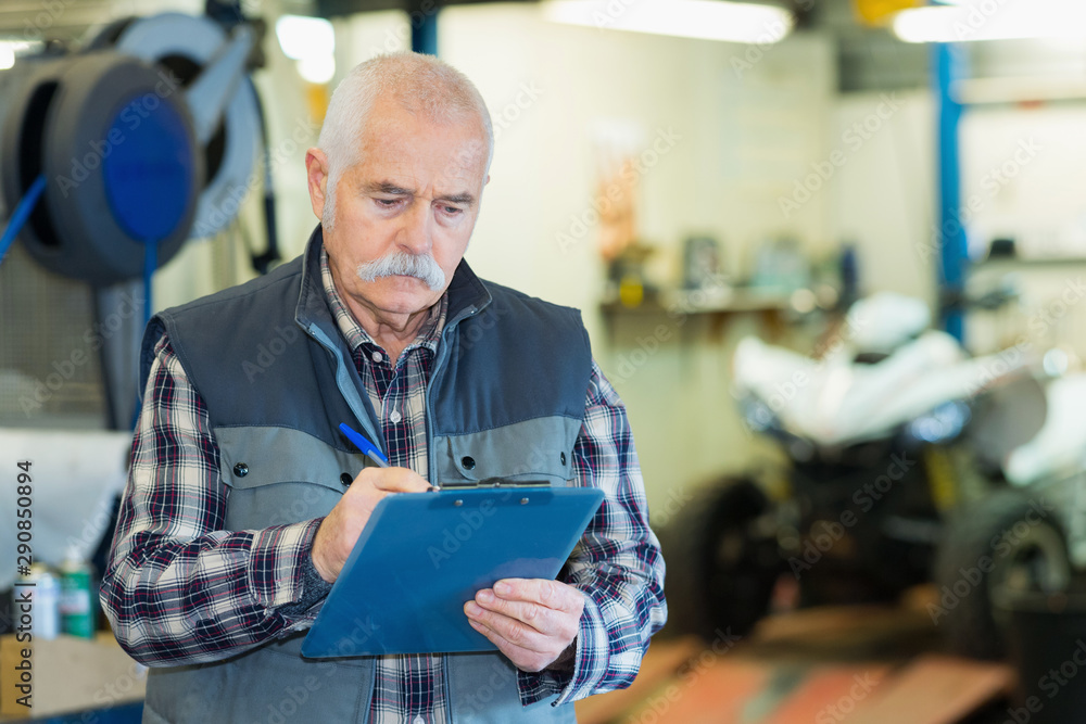 Fototapeta premium elderly mechanic checking quad vehicle