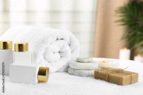 Composition with cosmetic products on white towel indoors. Spa therapy photo