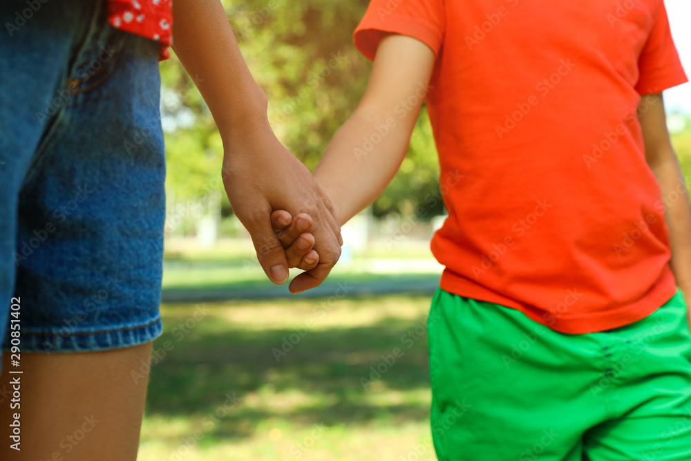 Little boy and his mother holding hands outdoors, closeup. Family weekend Little boy and his mother holding hands outdoors, closeup. Family weekend
