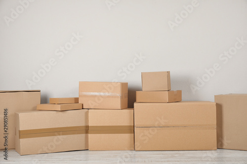 Pile of cardboard boxes near light wall indoors