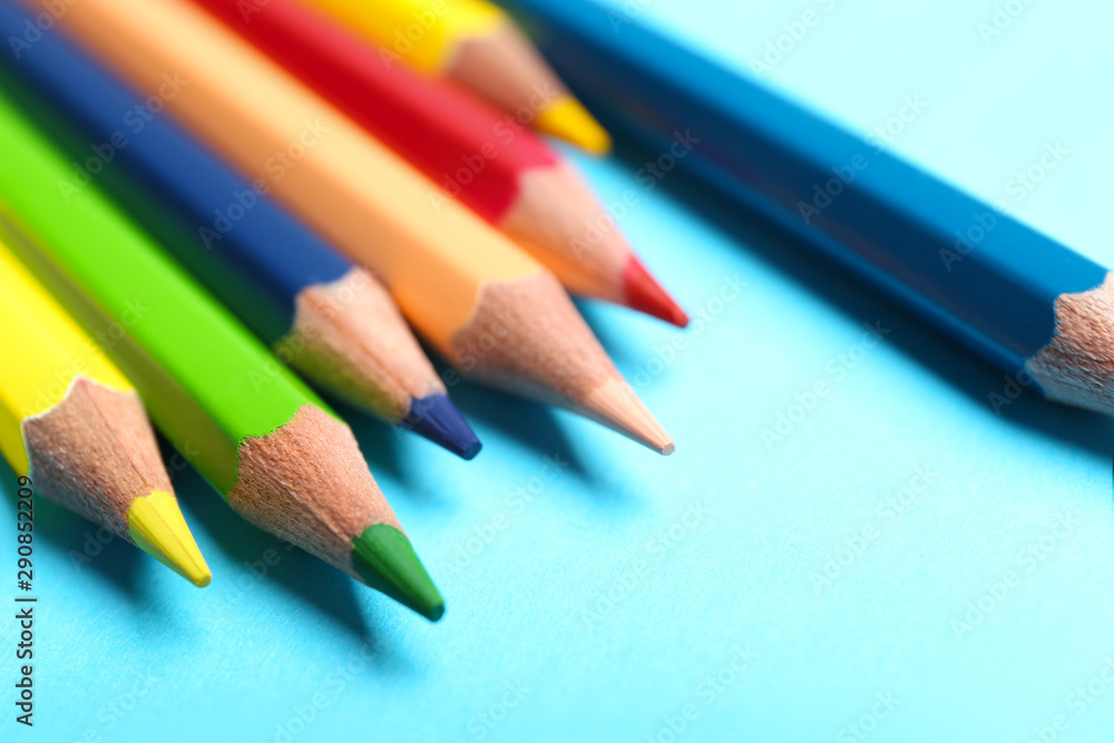Colorful pencils on light blue background, closeup Colorful pencils on light blue background, closeup
