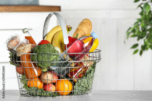 Bild auf Leinwand Shopping basket with grocery products on grey table indoors
