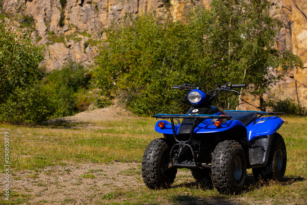 quad on a clearing against the backdrop of a rock wall, Borholm quad on a clearing against the backdrop of a rock wall, Borholm