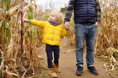 Family walking among the dried corn stalks in a corn maze.