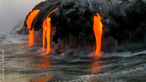 Sea view of Kilauea Volcano in Big Island, Hawaii, United States. A restless volcano that has been in business since 1983. Cinemagraph loop of lava flowing into the ocean.