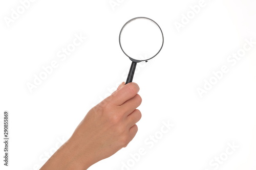 Female hand holding a magnifier.