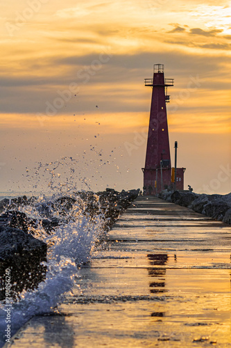 lighthouse at sunset with splash of water